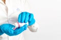 Close-up of hands in blue medical gloves holding a bottle with pills. The doctor gives a medication, vitamins and antibiotics