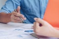 Close up hands of businesman discussing a financial plan with financial document graph in meeting room.