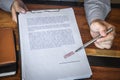 Close up hands of businessman pointing to signing and stamp on paper document to approve business investment contract agreement Royalty Free Stock Photo