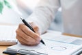 Close-up of hands Businessman reading and writing with pen signing contract over document for Completing Application Form at work