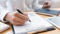 Close-up of hands Businessman reading and writing with pen signing contract over document for Completing Application Form at work Royalty Free Stock Photo