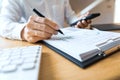 Close-up of hands Businessman reading and writing with pen signing contract over document for Completing Application Form at work Royalty Free Stock Photo