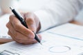 Close-up of hands Businessman reading and writing with pen signing contract over document for Completing Application Form at work