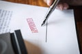Close up hands of businessman signing and stamp on paper document to approve business investment contract agreement Royalty Free Stock Photo