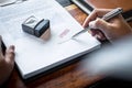 Close up hands of businessman signing and stamp on paper document to approve business investment contract agreement Royalty Free Stock Photo