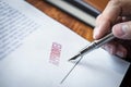 Close up hands of businessman signing and stamp on paper document to approve business investment contract agreement Royalty Free Stock Photo