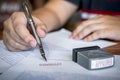 Close up hands of businessman signing and stamp on paper document to approve business investment contract agreement Royalty Free Stock Photo