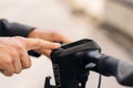 Close up hands of businessman turns on the electric scooter. Male is pushing start button of modern gadget on street of Royalty Free Stock Photo