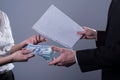 Close-up hands of businessmen giving away business papers in exchange for pre-dollar banknotes. Shadow scam. Illegal sale of