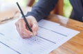 Close up of the hands of a businesswoman in a suit signing or writing a document on a sheet of white paper Royalty Free Stock Photo