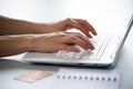 Close-up of hands of businesswoman typing on a laptop.