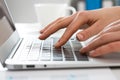 Close-up of hands of businesswoman typing on a laptop