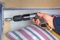 Close-up hands of a carpenter with pneumatic wrench.