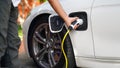 Close up hands charging power EV station for electric car vehicle.