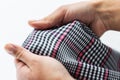 Close up of hands with checkered clothing item