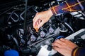 Close up hands checking lube oil level of car engine from deep-s
