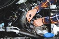 Close up hands checking lube oil level of car engine from deep-stick for service and maintenance concept