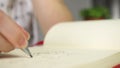 Close-up of hands of child usinf pencil for notebook at desk with laptop. Young girl drawing for fun, creativity and