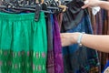 Close up of hands choosing skirts at street market