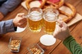 Close up of hands clinking beer mugs at bar or pub Royalty Free Stock Photo