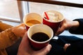 Close up hands with coffee cups at cheers time. friends have fun and drink coffee in the cafeteria
