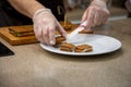 Close up of hands of a cook man in rubber gloves put on a white plate snacks grilled sandwiches. Close up, soft focus