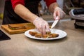 Close up of hands of a cook man in rubber gloves put on a white plate snacks grilled sandwiches. close up, soft focus