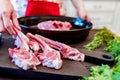 Cook puts raw lamb ribs on frying pan close up Royalty Free Stock Photo