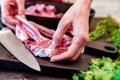 Cook puts raw lamb ribs on frying pan close up