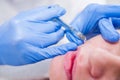 Close up Hands of cosmetologist making injection in face, lips. Young woman gets beauty facial injections in salon. Face aging, re Royalty Free Stock Photo