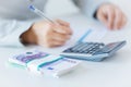 Close up of hands counting money with calculator Royalty Free Stock Photo