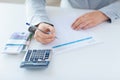 Close up of hands counting money with calculator Royalty Free Stock Photo