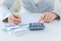 Close up of hands counting money with calculator Royalty Free Stock Photo