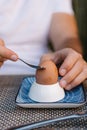 Close-up of hands cracking boiled egg shell in egg cup Royalty Free Stock Photo