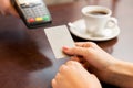 Close up of hands with credit card reader at cafe Royalty Free Stock Photo