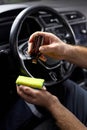 Close-up hands of cropped man applying anti dust and scratch liquid on cloth for cleaning the interior of auto Royalty Free Stock Photo