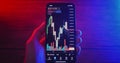 Close up hands of crypto trader holding mobile phone analyzes cryptocurrency price. Crypto investor makes money using