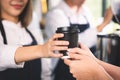 Close up hands customer receive the cup of hot coffee latte from barista. Coffee cafe shop beverage concept