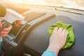 Close Up of hands disinfecting the inside of a car with antibacterial microfiber wet wipes and disinfectant fluid. hygiene and