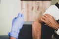 close up hands of Doctor hands given vaccination shot to elderly patient by syringe or injunction, patient rubbing his