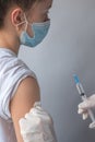 Close-up of the hands of a doctor or nurse giving a patient an injection into the shoulder with a syringe. Royalty Free Stock Photo