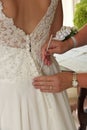 Close up of Hands Doing Final Buttoning of Bride& x27;s Wedding Dress Royalty Free Stock Photo