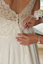 Close up of Hands Doing Final Buttoning of Bride& x27;s Wedding Dress Royalty Free Stock Photo