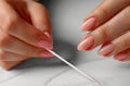 Close up of hands doing a french manicure on a white background, closeup view of a woman hand with a nail file and Royalty Free Stock Photo