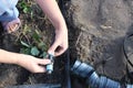 Close-up of the hands of an elderly Caucasian woman screwing a fitting onto a hose. A farmer installs a drip irrigation system on Royalty Free Stock Photo