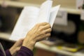 Close-up of hands of the elderly person with open book, bookstore. Real scene. Education concept, Self-study, reading Royalty Free Stock Photo