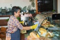 Close-up hands elderly woman wearing apron, wearing rubber gloves, right hand holding thin cloth for wiping glass, left hand holds