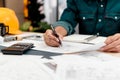 Close up hands of an engineer working and checking on blueprints. Engineer planning project on paperwork with equipment Royalty Free Stock Photo