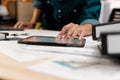 Close up hands of an engineer working and checking on blueprints with tablet. Engineer planning project on paperwork with equipmen Royalty Free Stock Photo