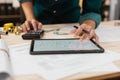 Close up hands of an engineer working and checking on blueprints with tablet. Engineer planning project on paperwork with equipmen Royalty Free Stock Photo